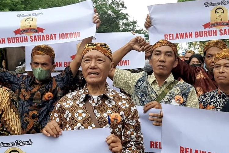 Relawan buruh Sahabat Jokowi menggelar aksi damai membentang poster bersamaan dengan acara ngunduh mantu Presiden Jokowi di Jalan Diponegoro Ngarsopuro tepatnya di depan pintu masuk Pura Mangkunegaran Solo, Jawa Tengah, Minggu (11/12/2022) sore.