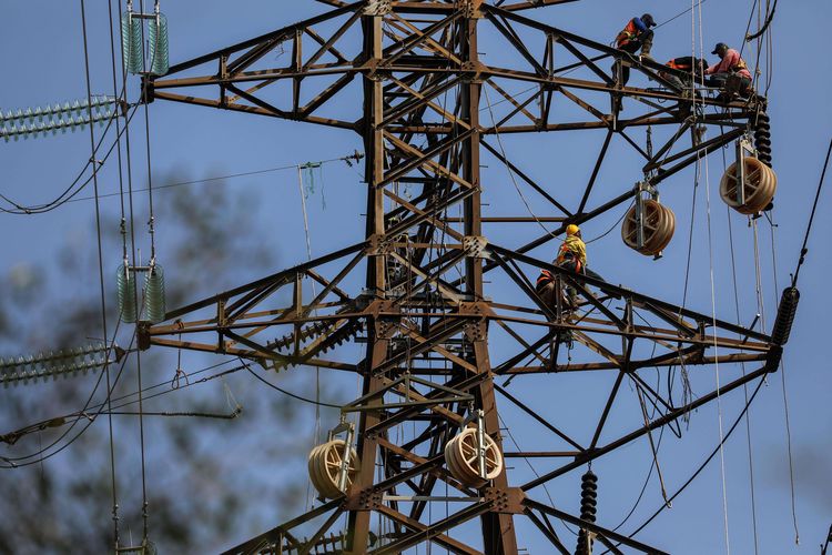 Sejumlah pekerja menyelesaikan pekerjaan rekonduktoring atau penggantian kabel konduktor jalur transmisi SUTT (Saluran Udara Tegangan Tinggi) 150.00 volt (150 kV) dari gardu induk Angke ke Karet lama di kawasan Petamburan, Tanah Abang, Jakarta, Sabtu (27/7/2019). 