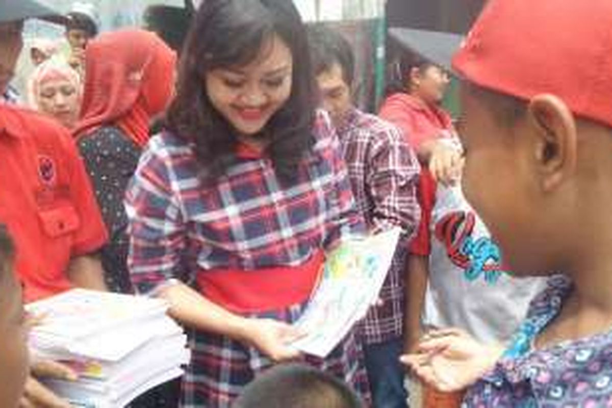 Istri cawagub DKI, Happy Farida, membagikan buku untuk anak-anak di kawasan Cakung, Minggu (13/11/2016). 
