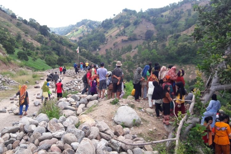 Ratusan warga berkonsentrasi diatas gunung dengan batu besar untuk menghadang aparat kepolisian mengamankan jalan elsekusi lahan rencana pembangunan bendungan Karaloe, Kecamatan Biringbuli, Kabupaten Gowa, Sulawesi Selatan. Kamis, (16/3/2017).