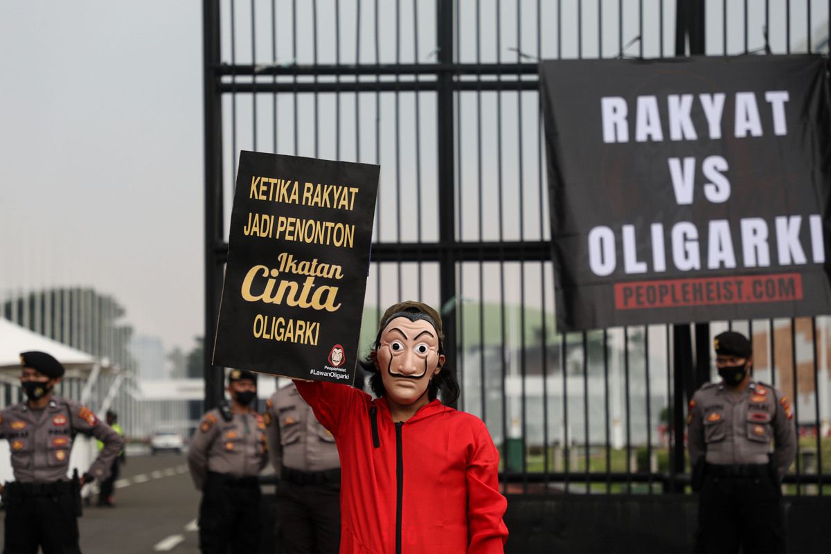 Aktivis yang tergabung dalam People Heist menunjukkan poster yang mereka bawa saat berunjuk rasa di depan Gedung Parlemen, Senayan, Jakarta, Senin (4/10/2021). Mereka antara lain menyuarakan dan memperingatkan tentang bahaya oligarki yang semakin merejalela khususnya pascapengesahan UU Cipta Kerja. Pengesahan UU yang banyak mendapat protes dari masyarakat tersebut mereka nilai lebih banyak merugikan rakyat dibanding memberi manfaat.
