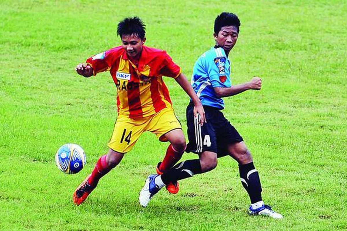 Pemain SSB Rajawali Muda, Dimas Hargiharso (kiri), berebut bola dengan pemain SSB ASIOP Apacinti, Nur Rokhim, pada pertandingan Liga Kompas Gramedia U-14 musim 2012 di Stadion Ciracas, Jakarta Timur, Minggu (8/1). 