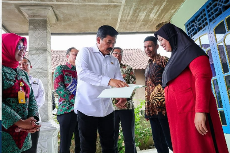Menteri ATR/Kepala BPN  Hadi Tjahjanto menyerahkan sertifikat kepada masyarakat di Desa Bumi Agung, Kabupaten Pesawaran, Lampung, Kamis (26/10/2023). 
