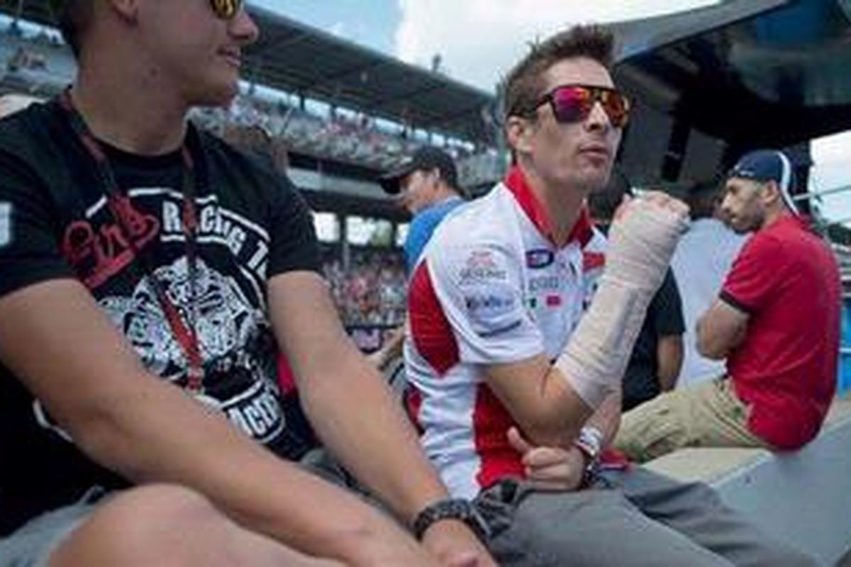 Pebalap Ducati, Nicky Hayden, saat menyaksikan GP Indianapolis, Minggu (19/8/2012). Dia menyaksikan balapan itu dengan tangan kanan terbungkus perban akibat cedera yang dialami saat kecelakaan kualifikasi GP Indianapolis, Sabtu (18/8).