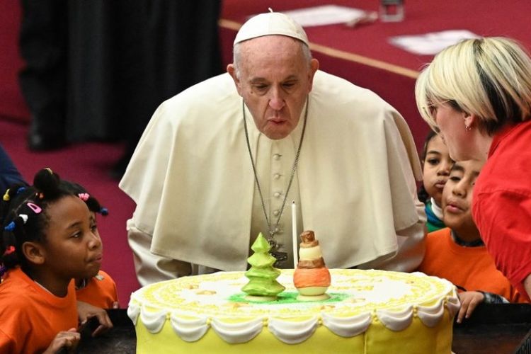 Paus Fransiskus meniup lilin kue untuk ulang tahun yang ke-82, selama acara audiensi dengan anak-anak dan keluarga pada Minggu (16/12/2018) di Vatikan. Paus berulang tahun pada 17 Desember. (AFP/Vincenzo Pinto)