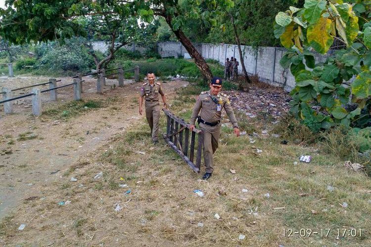 Aparat Satuan Polisi Pamong Praja Kabupaten Madiun mengangkat tangga kayu yang sering digunakan pria hidung belang melarikan diri saat ada razia prostitusi terselubung di Pasar Muneng, Kecamatan Pilangkenceng, Selasa ( 12/9/2017). 