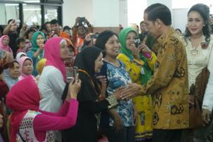Presiden Joko Widodo menyalami para ibu yang hadir dalam perayaan Hari Ibu di GOR Ciracas, Senin (22/12/2014)