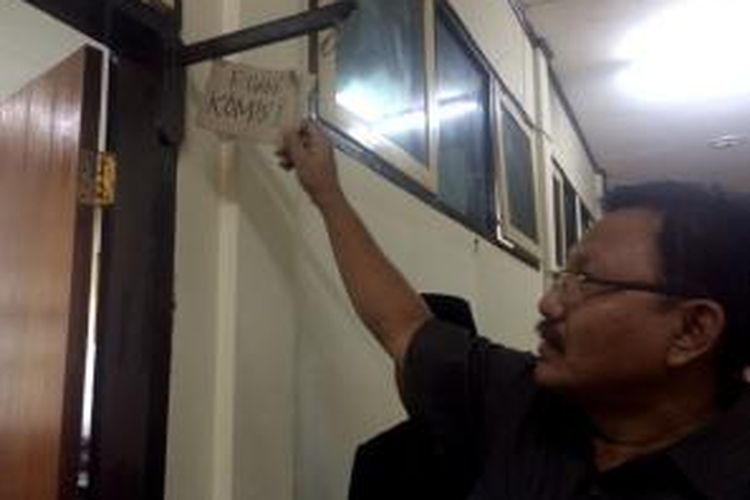 Wakil Ketua DPRD Pamekasan, Suli Faris, memasang plakat dari kardus bekas sebagai pengganti nama ruangan kerja komisi DPRD Pamekasan, Senin (16/3/2015).