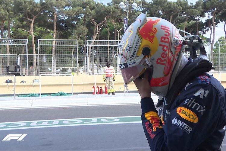 Pebalap Red Bull Max Verstappen tertunduk lesu saat berjalan kembali ke pitlane setelah ban kiri mobilnya pecah, lima lap sebelum garis finis di GP Azerbaijan, Minggu (6/6/2021).