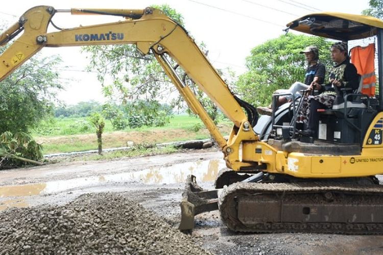 Bupati Wihaji saat mengendarai eksavator untuk meratakan Lapisan Pondasi Atas (LPA) di Jalan Basuki Ramat Batang Jawa Tengah.