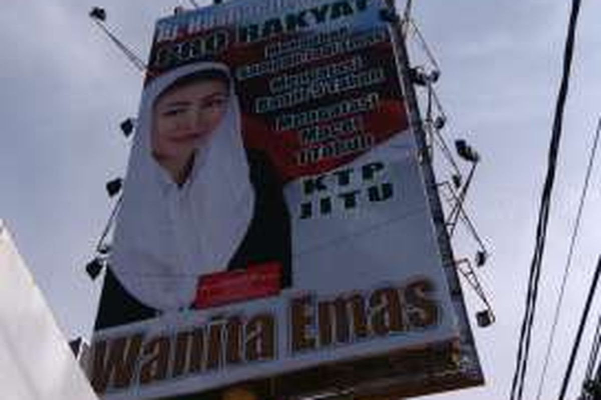 Sebuah reklame bergambar wajah Mischa Hasnaeni Moein atau Wanita Emas di Jalan Warung Jati Barat, kawasan Buncit, Jakarta Selatan, dipasang segel merah. Keterangan segel itu menyatakan bahwa reklame tersebut belum membayar pajak. Foto diambil Jumat (6/5/2016)