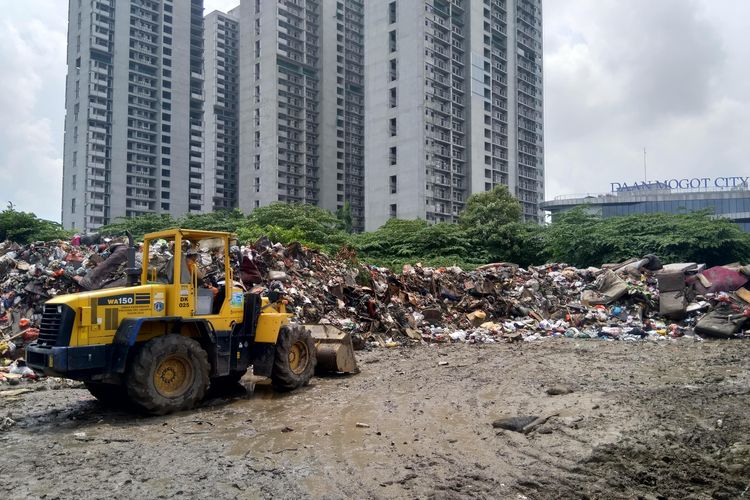 Petugas LH sedang menggerakkan dozer untuk merapihkan sampah di TPS RW 01 Kelurahan Semanan.