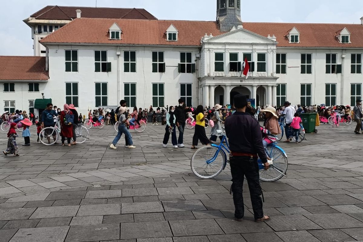 Pengunjung yang berkeliling dengan sepeda ontel di depan bangunan Museum Fatahillah, Jakarta, Selasa (25/4/2023). Ratusan sepeda ontel yang sudah dimodifikasi dengan cat warna-warni itu disewa banyak disewa oleh para pengunjung.