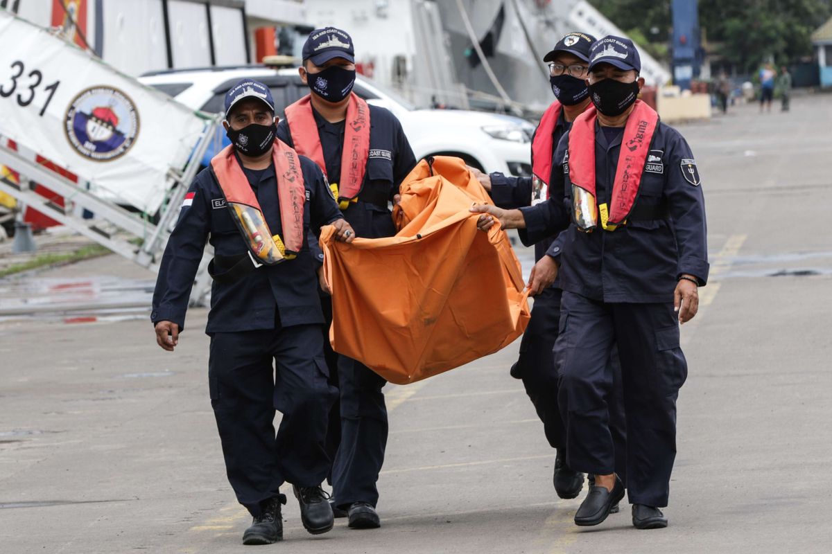 Petugas membawa serpihan pesawat Sriwijaya Air SJ 182 rute Jakarta - Pontianak yang jatuh di perairan Kepulauan Seribu di Posko SAR Sriwijaya Air, Dermaga JICT II, Tanjung Priok, Jakarta, Rabu (13/1/2021).