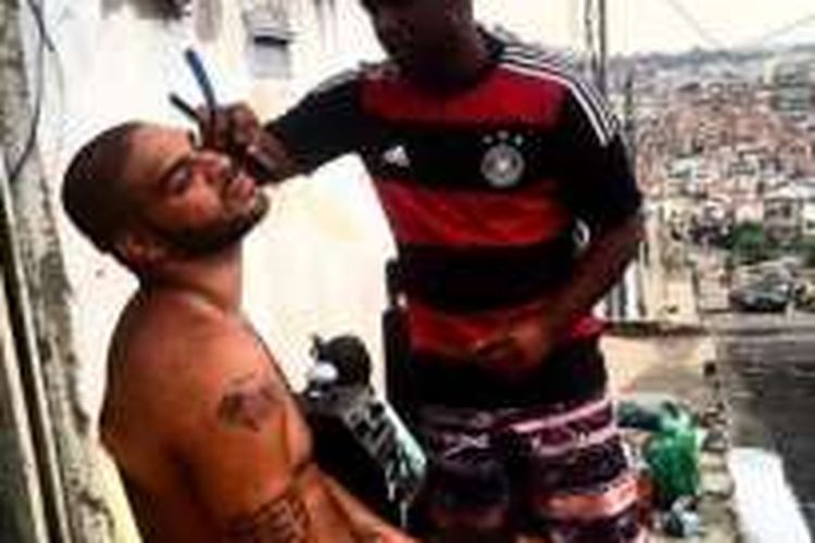 Adriano Leite Ribeiro tengah mencukur janggut di daerah Favela, Rio De Janeiro, Brasil. 