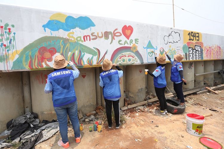 Pengecetan ulang mural di wilayah Kampung Pelangi, Kamal Muara, Jakarta Utara oleh para relawan Samsung.