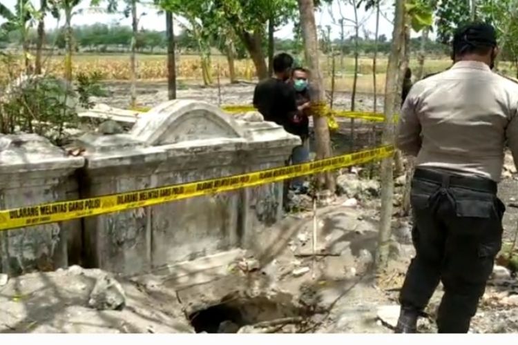 Petugas Kepolisian memasang garis polisi dan melakukan olah TKP di makam warga Thionghoa di Desa Wotangare, Kecamatan Kalitidu, Bojonegoro, yang dibongkar orang tak dikenal.