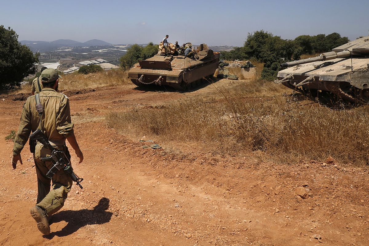 Tentara Israel berjalan dengan tank Merkava dan kendaraan angkut personel Namer dekat kota Avivim, di utara Israel berbatasan dengan Lebanon pada 23 Juli 2020.