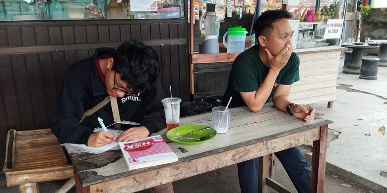 Dua pelajar bahasa mandarin di Kampung Inggris Kecamatan Pare, Kabupaten Kediri, Jawa Timur, tengah belajar di sela-sela istrahat siangnya, medio Februari 2025.