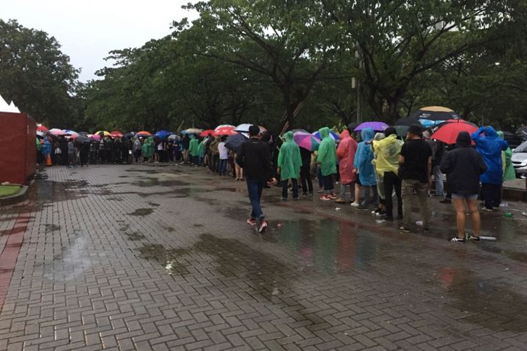 Di bawah guyuran hujan para penonton dengan sabar mengantre masuk Econvention Ancol, Jakarta Utara, Minggu (14/1/2018) untuk menyaksikan konser musisi asal Inggris Liam Gallagher.