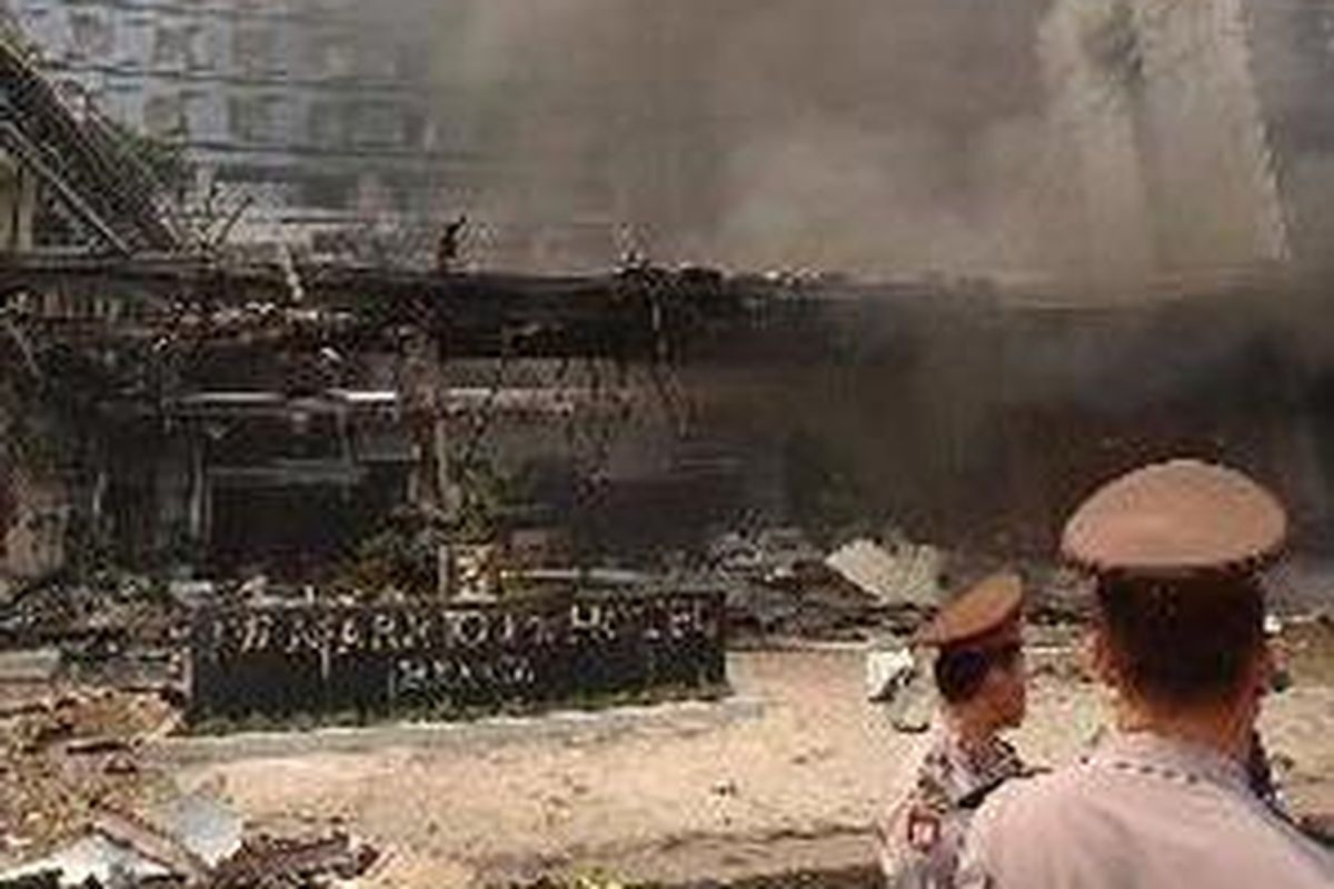 Beberapa polisi berdiri di depan hotel JW Marriot yang berantakan akibat ledakan bom beberapa tahun lalu