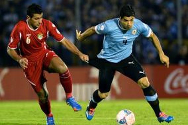Penyerang Uruguay Luis Suarez berebut bola dengan bek Yordania Tareq Khattab dalam pertandingan leg kedua babak play off antara Uruguay kontra Yordania yang berlangsung di Stadion Centenario, Montevideo, Kamis (21/11/2013)