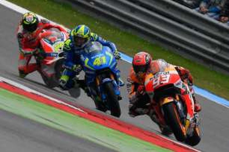 Pebalap Repsol Honda asal Spanyol, Marc Marquez (depan), memacu motornya di depan pebalap Suzuki Ecstar asal Spanyol, Aleix Espargaro (tengah), dan pebalap Ducati asal Italia, Andrea Iannone, pada balapan GP Belanda di Sirkuit Assen, Minggu (26/6/2016).