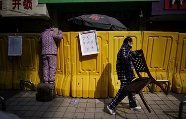 Seorang penduduk membayar makanan dengan berdiri di atas pagar pembatas di pasar basah Wuhan, provinsi Hubei, China. Foto diambil pada 1 April 2020.