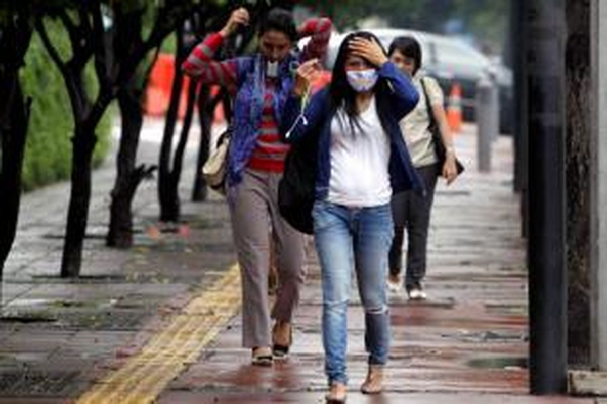 Warga menggunakan masker ketika beraktifitas di sekitar Bundaran Hotel Indonesia, Jakarta Pusat, Kamis (11/4/2013).