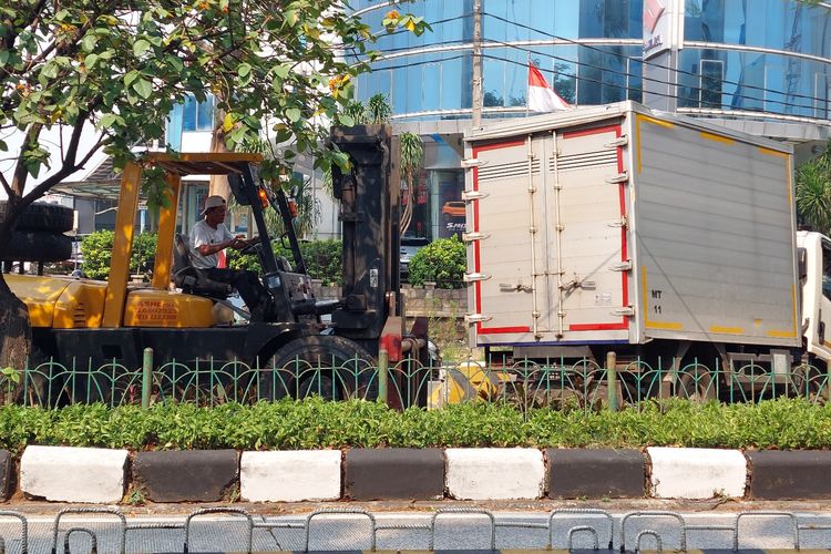 Sebuah mobil boks kontainer bernomor polisi B 9093 BCX sedang dievakuasi dengan alat berat usau menabrak pembatas jalan di Jalan Panjang, Kebon Jeruk, Jakarta Barat, pada Senin (15/8/2022) pukul 14.10 WIB.