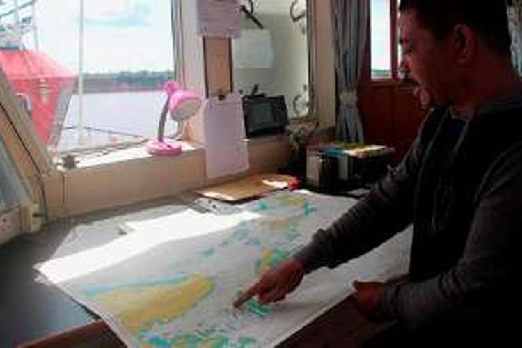 Alit Rukmana (43), kapten kapal tunda Oceanus 201, menjelaskan rute pelayaran yang biasa dilalui kapalnya yang menarik tongkang batubara dari Banjarmasin ke Filipina di ruang kemudi kapalnya yang bersandar di Pelabuhan Banjar Raya, Banjarmasin, Kalimantan Selatan, Selasa (19/4). 
