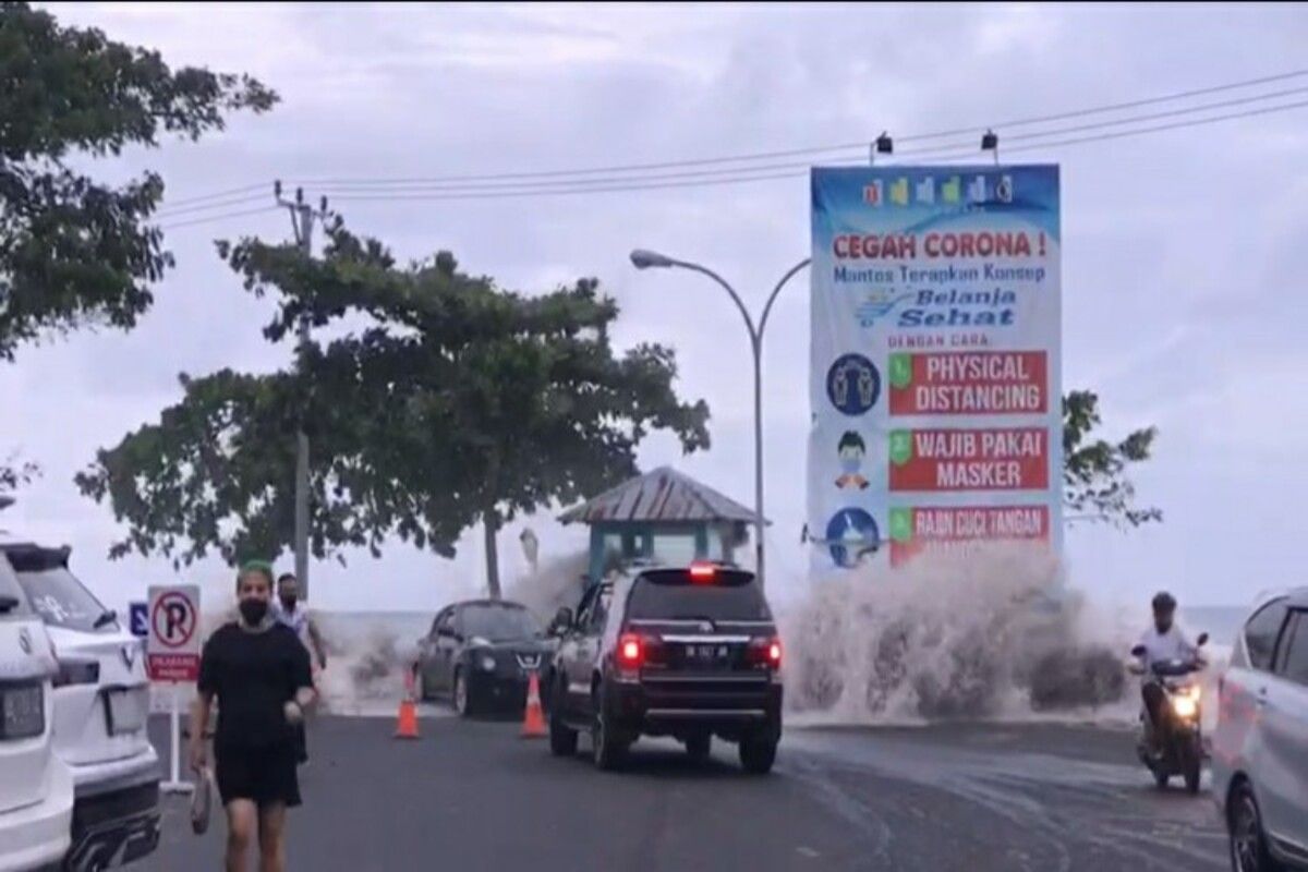 Tangkapan layar ombak mengamuk di Pantai Manado, beberapa tampak berlarian mencari lokasi aman, Minggu (17/1/2021)