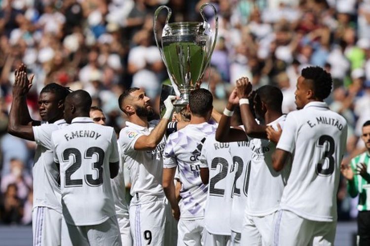 Karim Benzema (tengah) mengangkat trofi Liga Champions di antara para pemain Real Madrid. Trofi Liga Champions dan La Liga dipamerkan di Stadion Santiago Bernabeu sebelum laga Real Madrid vs Real Betis pada pekan keempat Liga Spanyol 2022-2023, Sabtu (3/9/2022) siang waktu setempat.