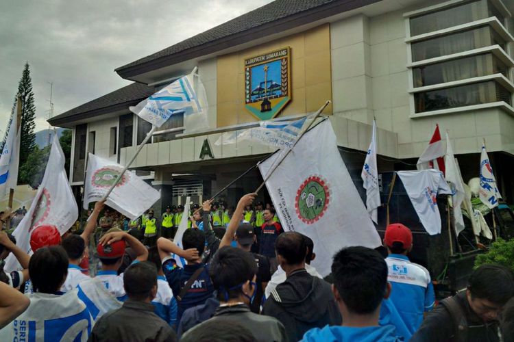 Sekitar seribu buruh dari berbagai organisasi buruh di Kabupaten Semarang yang tergabung dalam Gerakan Masyarakat Pekerja Ungaran (Gempur), berunjuk rasa menyoal Upah Minimum Kabupaten (UMK) di Kantor Bupati Semarang, Jumat (17/7/2017).