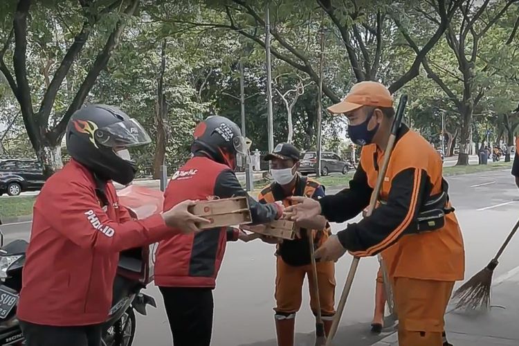Driver Pizza Hut membagikan pizza kepada petugas kebersihan