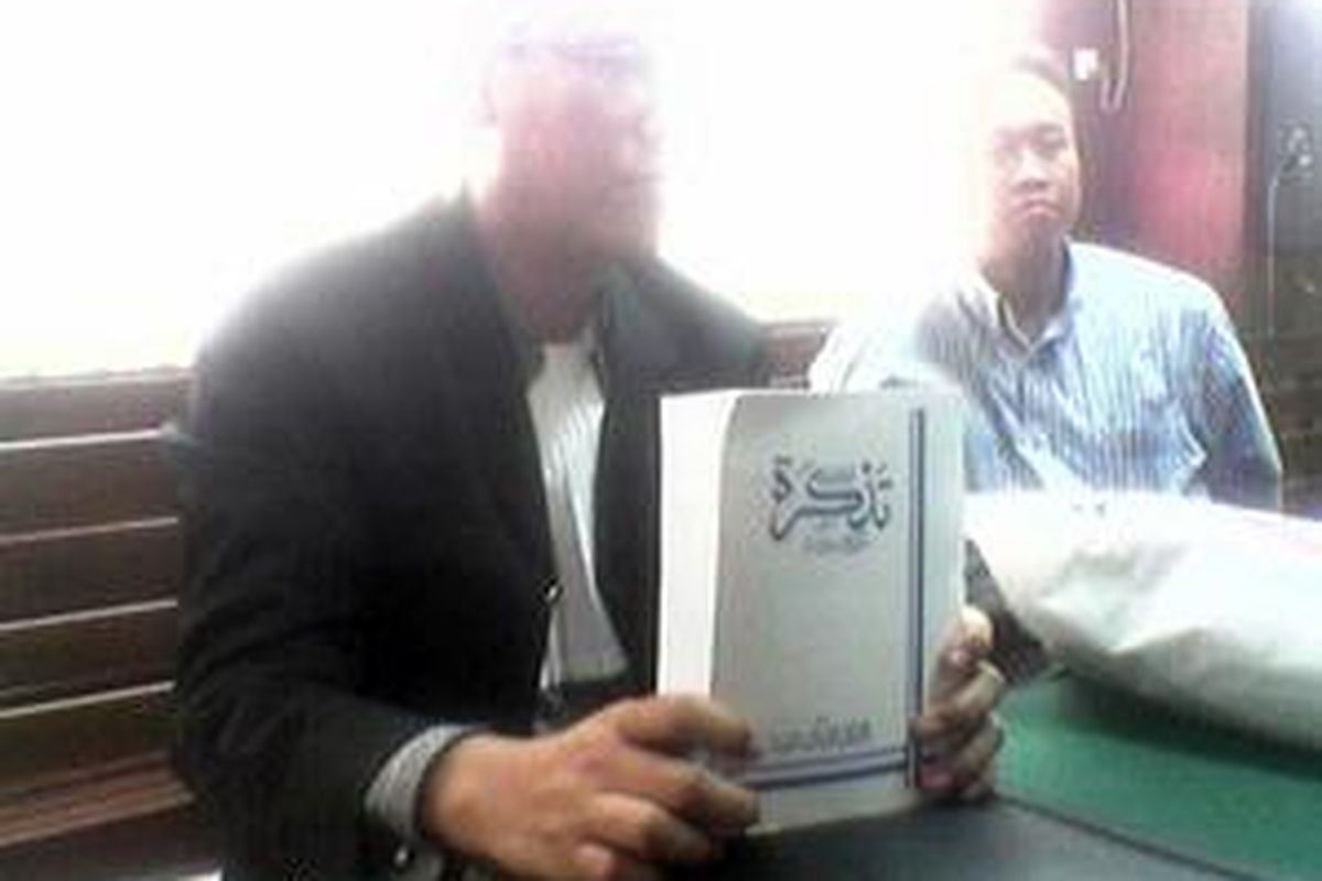 Salah satu kuasa hukum Rizieq memegang kitab suci jemaah Ahmadiyah, kitab Tadzkirah. Kuasa hukum Rizieq yang tergabung dalam Tim Pengacara Muslim�(TPM), Senin (22/9), menyediakan kitab ini sebagai solusi untuk proses pengambilan sumpah saksi Ahmadiyah.