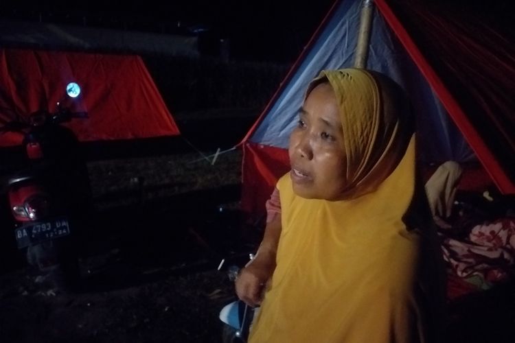 Simur (48), salah satu pengungsi bencana gempa bumi yang tak kebagian tenda, kasur dan selimut saat berada di pokso pengungsian di Kantor Kecamatan Tigo Nagari, Kabupaten Pasaman, Sumbar, Sabtu (26/2/2022) malam.