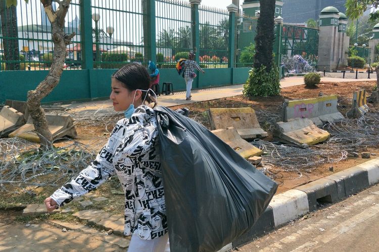 Selebgram Awkarin membawa kantong plastik berisikan sampah di depan gedung DPR Ri,
