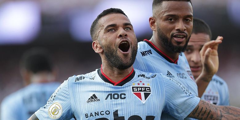 Pemain Sao Paulo, Dani Alves, merayakan gol yang ia cetak ke gawang Ceara pada ajang Liga Brasil, Minggu (18/8/2019).