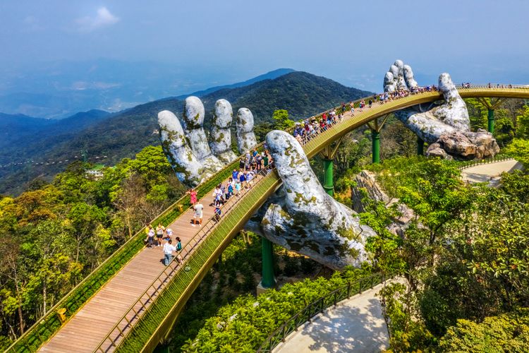 Ilustrasi Golden Bridge atau Jembatan Emas yang seolah-olah diangkat oleh dua tangan raksasa di Ba Na Hill (Bukit Ba Na) di Da Nang, Vietnam.