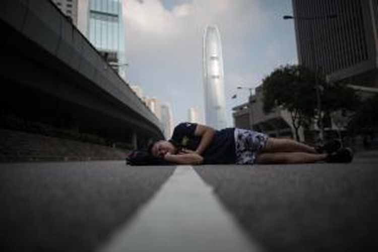Kelelahan, seorang pengunjuk rasa pro-demokrasi tertidur di jalanan kota Hongkong. Selama sepekan ribuan warga Hongkong melakukan unjuk rasa menuntut pemilihan umum yang bebas.