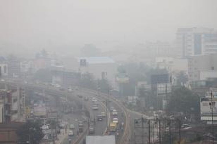 Sejumlah kendaraan melintasi jalan layang di Jalan Jenderal Sudirman, Pekanbaru, yang diselimuti kabut asap, Senin (24/2/2014). Kabut asap di Pekanbaru semakin bertambah pekat akibat kebakaran lahan dan hutan, menurut data BMKG Pekanbaru melalui satelit Terra dan Aqua terdapat 1.234 hotspot di Riau. 
