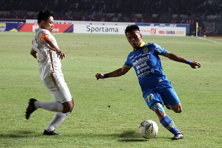 Winger Persib Bandung, Ghozali Siregar (biru), melewati hadangan Kapten PSS Sleman, Bagus Nirwanto (putih). 