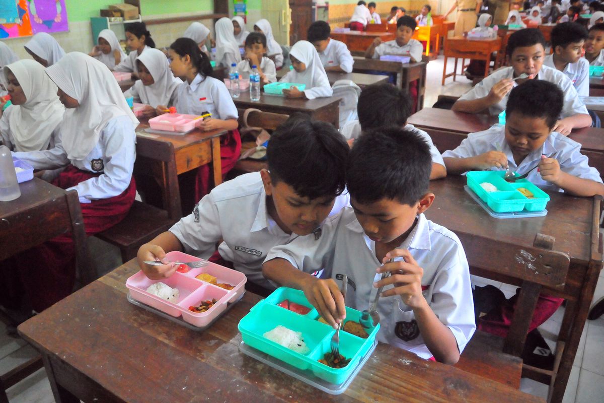 Siswa menyantap makanan saat pelaksanaan uji coba makan bergizi gratis di SDN 2 Wergu Wetan, Kudus, Jawa Tengah, Senin (30/9/2024). Simulasi makan siang gratis dengan menu nasi, sayur, nuget dan susu UHT serta buah tersebut sebagai upaya mencegah stunting anak serta mempersiapkan generasi emas Indonesia. ANTARA FOTO/Yusuf Nugroho/Spt.