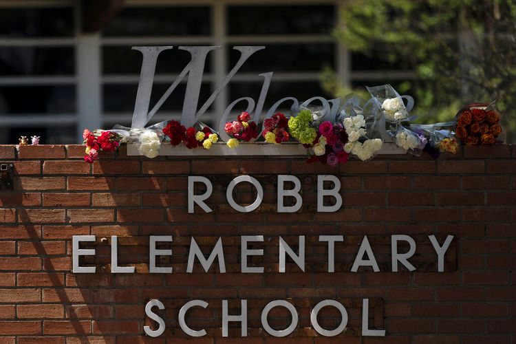 Bunga ditempatkan di sekitar tanda selamat datang di luar Sekolah Dasar Robb di Uvalde, Texas, Rabu, 25 Mei 2022, untuk menghormati para korban yang tewas dalam penembakan hari Selasa di sekolah tersebut. 