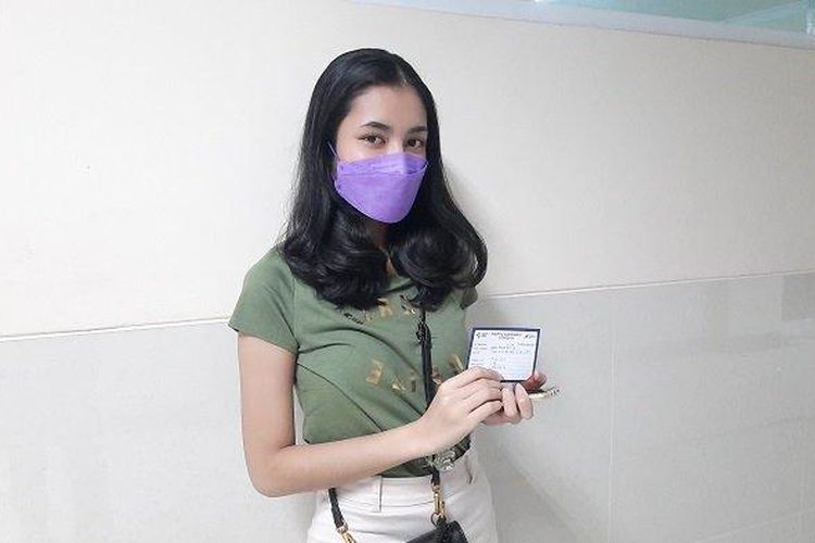 Dinda Athifa (19), seorang mahasiswi menunjukkan sebuah surat dosis pertama vaksinasi Covid-19, Selasa (29/6/2021). Dinda Athifa diketahui menjalani vaksinasi Covid-19 di Gedung Universitas Pamulang, Jalan Raya Puspiptek, Kelurahan Buaran, Kecamatan Serpong, Kota Tangerang