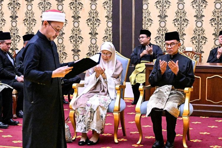 Perdana Menteri baru Malaysia Anwar Ibrahim (tengah, kanan), didampingi istrinya, Wan Azizah Wan Ismail (tengah, kiri), diambil sumpahnya dalam upacara pelantikan di Istana Nasional, Kuala Lumpur, Malaysia, Kamis (24/11/2022).