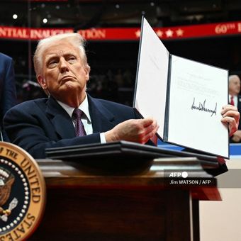 Presiden Amerika Serikat Donald Trump menunjukkan surat ke PBB yang berisi AS keluar dari Paris Agreement (perjanjian iklim), saat pelantikannya di Capital One Area, Washington DC, Senin (20/1/2025).