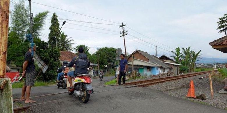 
Perlintasan rel KA Leuwidahu, Kota Tasikmalaya, tanpa dilengkapi palang pintu resmi, namun dijaga relawan warga setempat, Senin (14/11/2022) 
