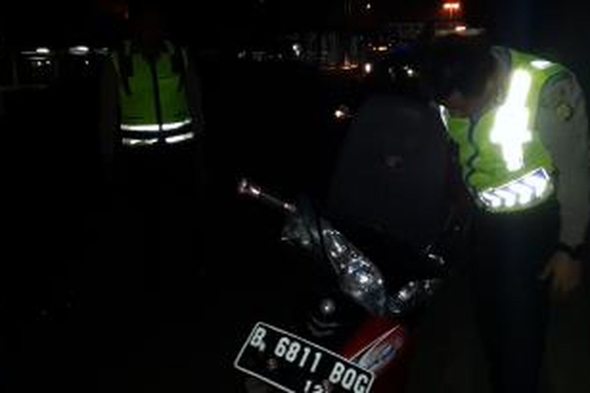 Polisi memeriksa kendaraan sepeda motor yang jatuh dan ditinggal pemiliknya di daerah Cengkareng, Jakarta Barat, Sabtu (7/3/2015).